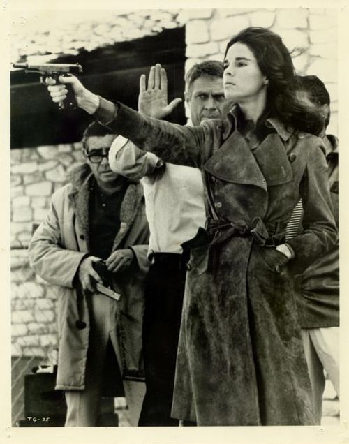 Steve McQueen teaches Ali MacGraw how to handle a pistol.